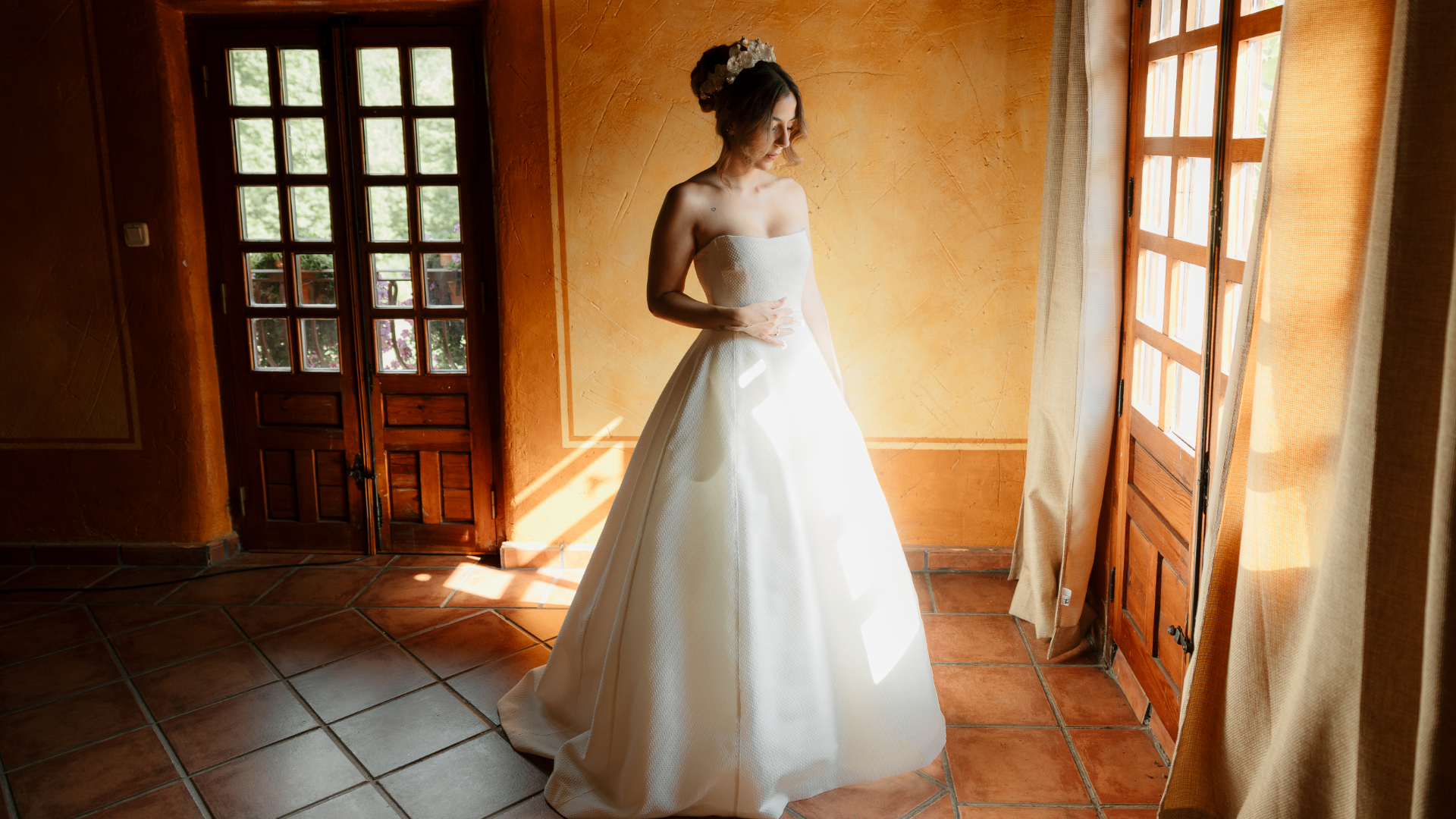 Fotografía de la novia Sandra ajustándose el vestido antes de su boda en un entorno industrial, capturada por fotógrafo de bodas en Valladolid