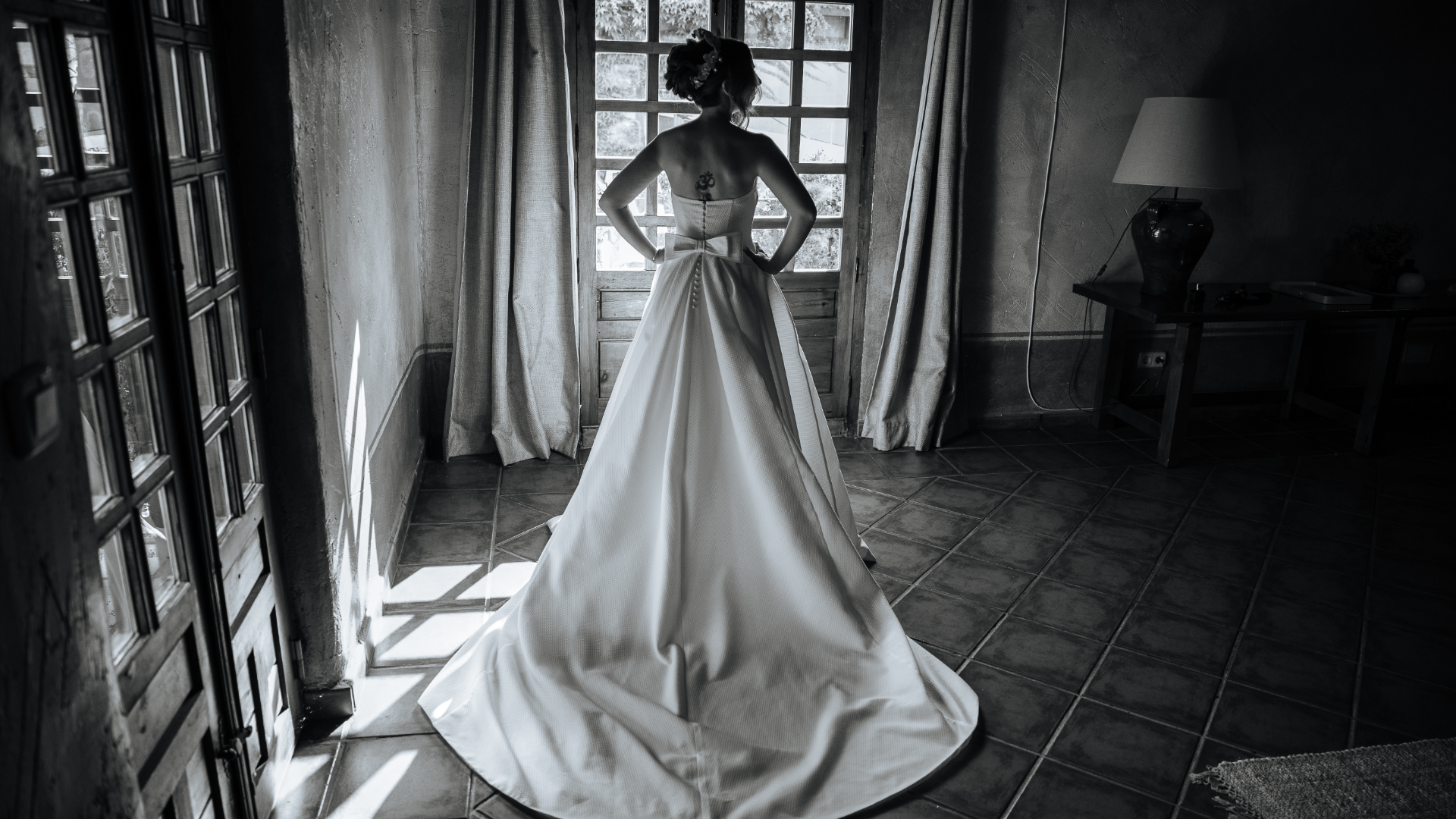 Fotografía de la novia Sandra ajustándose el vestido antes de su boda en un entorno industrial, capturada por fotógrafo de bodas en Valladolid