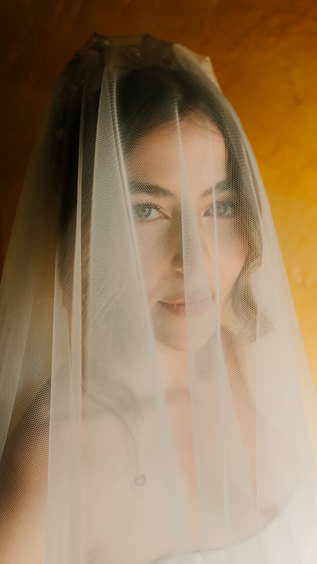 Fotografía de la novia Sandra ajustándose el vestido antes de su boda en un entorno industrial, capturada por fotógrafo de bodas en Valladolid